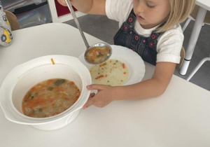 dziewczynka sama nalewa sobie zupę